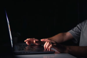 Young man works at the computer at night.