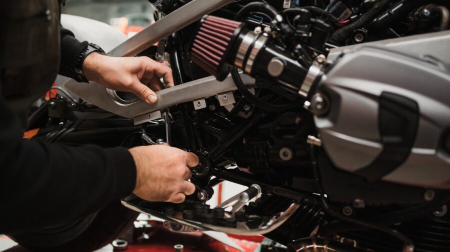 Man fixing a motorcycle in a modern workshop