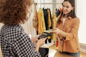 mulher-pagando-roupas-na-loja compras loja comércio FreePik